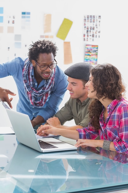 Équipe créative travaillant ensemble sur un ordinateur portable