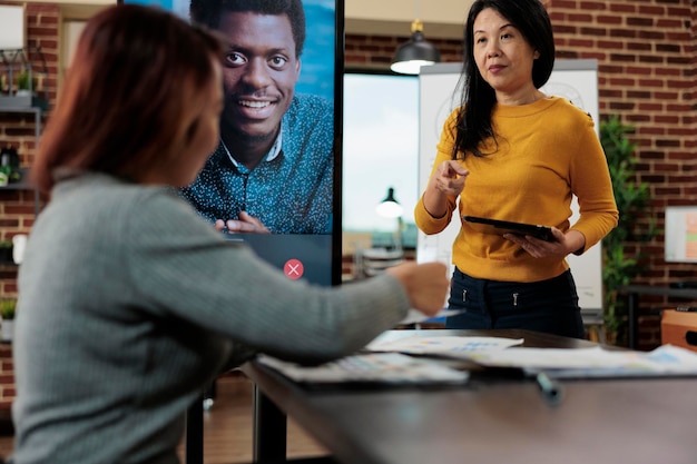 L'équipe de direction discute de la stratégie de l'entreprise avec un entrepreneur à distance lors d'une réunion de conférence vidéo en ligne dans le bureau de démarrage. Hommes d'affaires travaillant au projet de partenariat. Téléconférence