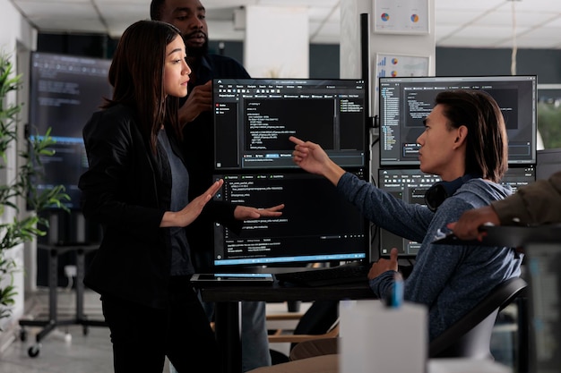 Une équipe diversifiée de programmeurs codant des informations de script html sur un ordinateur à la table de bureau, analysant le code source dans une agence de logiciels. Développeurs Web compilant des algorithmes de serveur en ligne innovants dans le langage des applications.