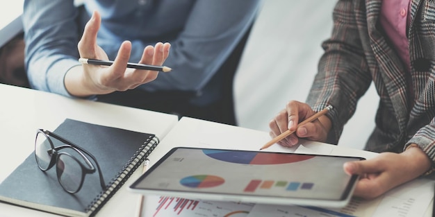 Photo Équipe de gestionnaires de fonds consulte et discute de l'analyse du marché boursier des investissements par tablette numérique