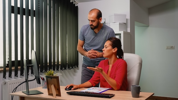 Equipe d'hommes d'affaires travaillant avec un nouveau projet de démarrage dans un loft moderne. Consultation en équipe sur un lieu de travail professionnel, dans une entreprise personnelle tapant sur un clavier d'ordinateur en regardant le bureau