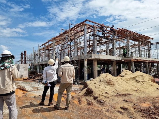 L'équipe d'ingénieurs en construction se promène sur le site pour suivre la construction de la sous-station du bâtiment de contrôle