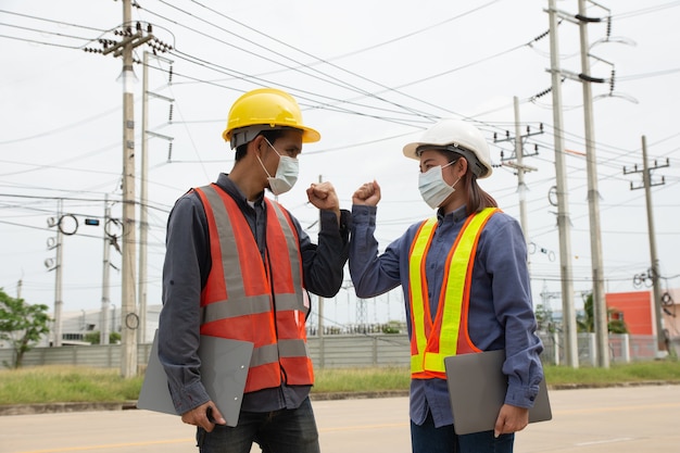 Une équipe d'ingénieurs électriciens inspecte la qualité de l'installation des poteaux haute tension