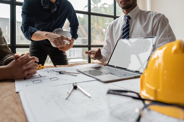 Photo Équipe d'ingénieurs se réunissant pour signaler la construction du projet sur l'écran d'un ordinateur portable