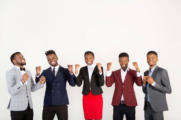 équipe de jeunes africains en costume avec les mains en l'air