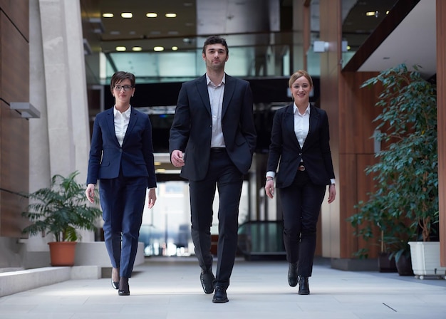 équipe de jeunes gens d'affaires marchant, groupe de personnes à l'intérieur du hall de bureau moderne