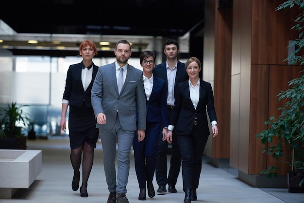 équipe de jeunes gens d'affaires marchant, groupe de personnes à l'intérieur du hall de bureau moderne