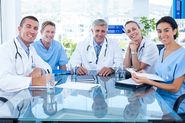 Équipe de médecins souriant à la caméra