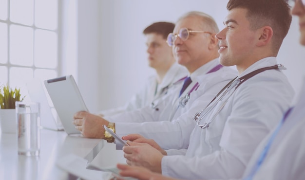 Équipe médicale assise et discutant à table