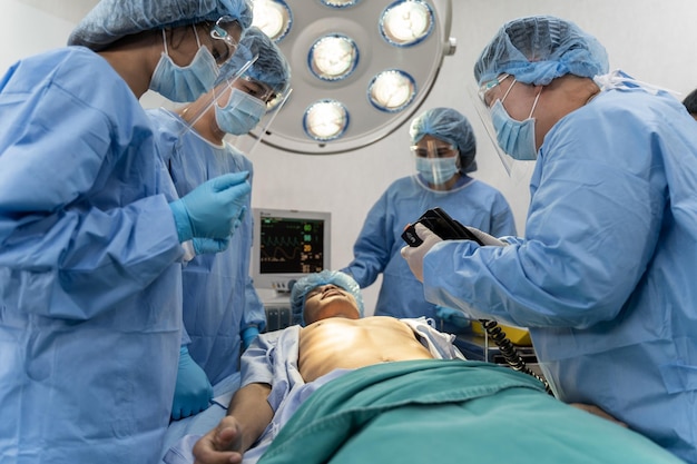 Photo une équipe médicale en blouse chirurgicale aide le patient à effectuer une réanimation cardio-pulmonaire rcr dans la salle d'opération de l'hôpital