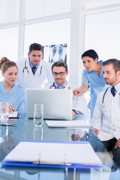 Équipe médicale concentrée utilisant un ordinateur portable ensemble