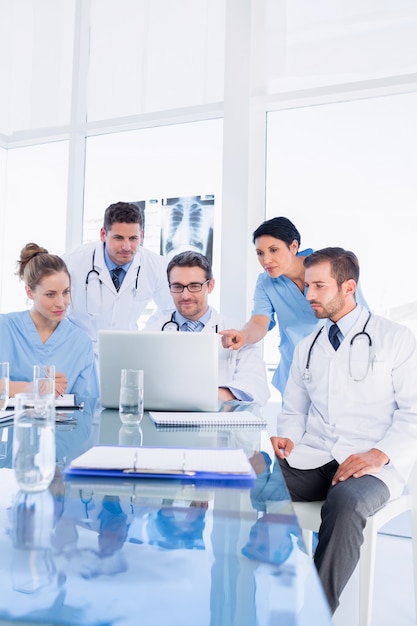 Équipe médicale concentrée utilisant un ordinateur portable ensemble