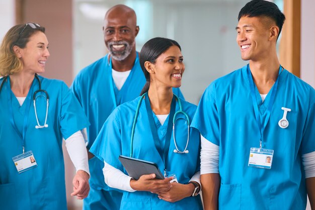Une équipe médicale multiculturelle souriante portant des gants parle dans un hôpital moderne