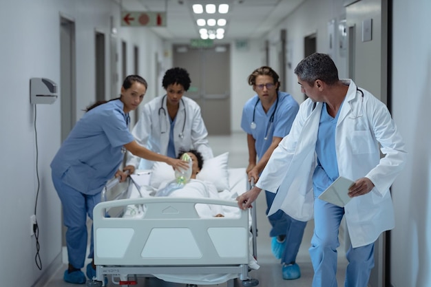 Une équipe médicale pousse un lit de civière d'urgence dans le couloir.