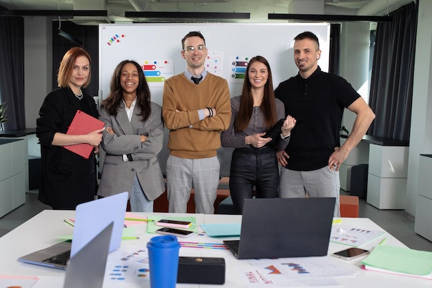 L'équipe multinationale de démarrage pose pour l'appareil-photo dans le bureau