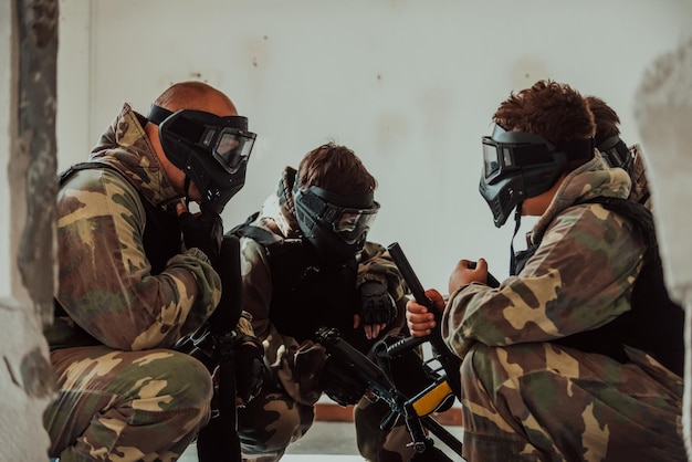 L'équipe de paintball s'accorde sur la tactique avant le début du combat Mise au point sélective Photo de haute qualité