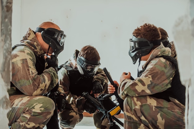 L'équipe de paintball s'accorde sur la tactique avant le début du combat Mise au point sélective Photo de haute qualité