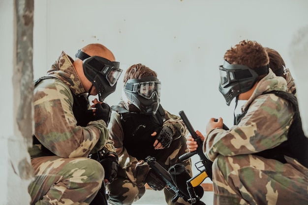 L'équipe de paintball s'accorde sur la tactique avant le début du combat Mise au point sélective Photo de haute qualité