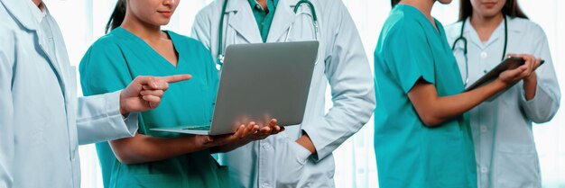 Photo Équipe de personnel médical composée de médecins, d'infirmières et de spécialistes de la santé travaillant ensemble avec un ordinateur portable et une tablette à l'hôpital lieu de travail médical et communauté de soins de santé dans la bannière panoramique neoteric