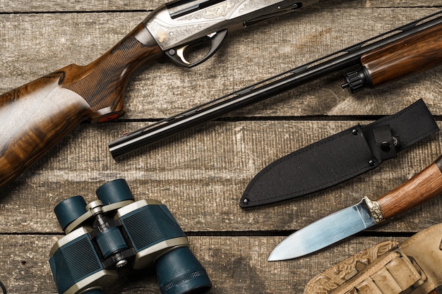 Équipement de chasse sur le vieux fond en bois comprenant des jumelles et des cartouches de couteau de fusil
