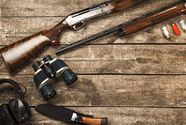 Équipement de chasse sur le vieux fond en bois comprenant des jumelles et des cartouches de couteau de fusil