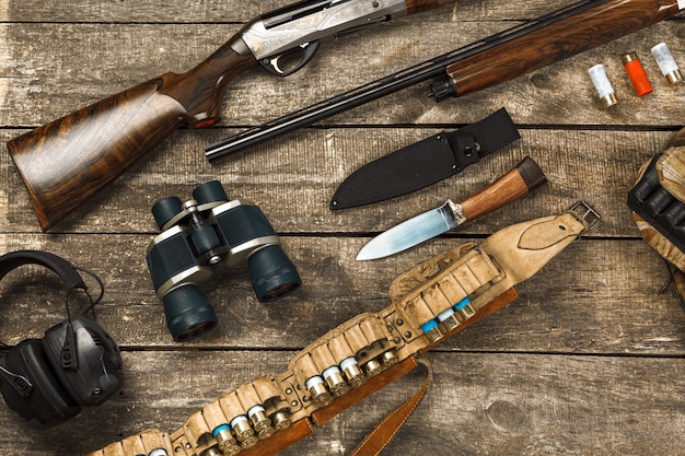 Équipement de chasse sur le vieux fond en bois comprenant des jumelles et des cartouches de couteau de fusil