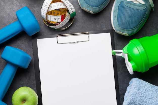 Photo Équipement de fitness et feuille vierge pour l'entraînement