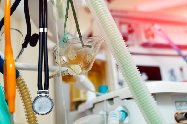 Equipement médical et tasse avec des pièces suspendues à un poteau dans une chambre d'hôpital