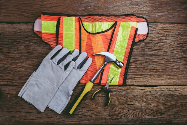 Photo Équipement de sécurité de construction standard avec des outils de travail sur la table en bois. vue de dessus