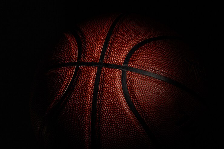 Photo équipement de sport professionnel isolé sur fond de studio noir. ballon de basket.