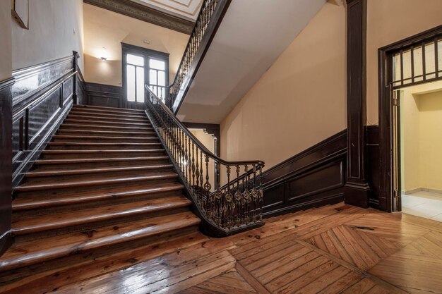 Escalier en bois avec garde-corps en métal et mains courantes en bois dans un ancien immeuble résidentiel du centre de Madrid