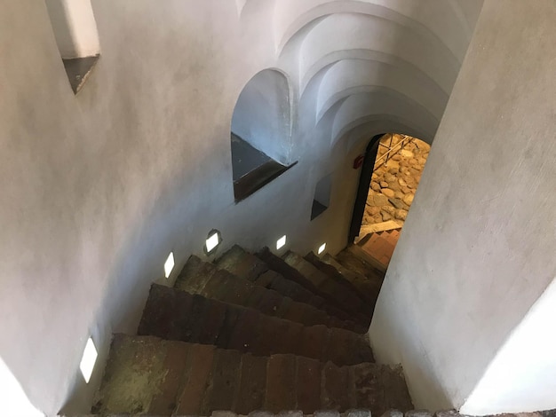 Escalier en colimaçon en pierre raide descendant des marches