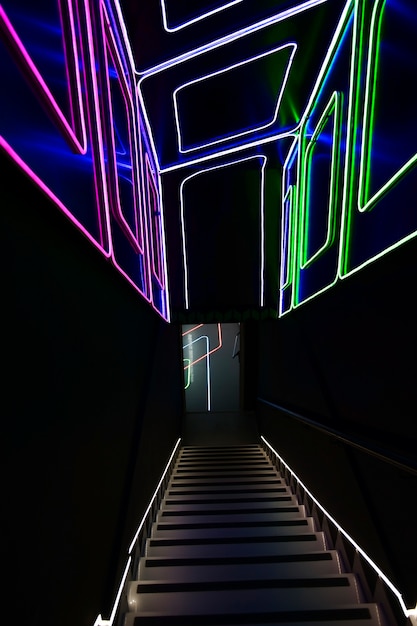 escalier illuminé décoré de motifs de lignes au néon sur les murs et le plafond entrée de la discothèque