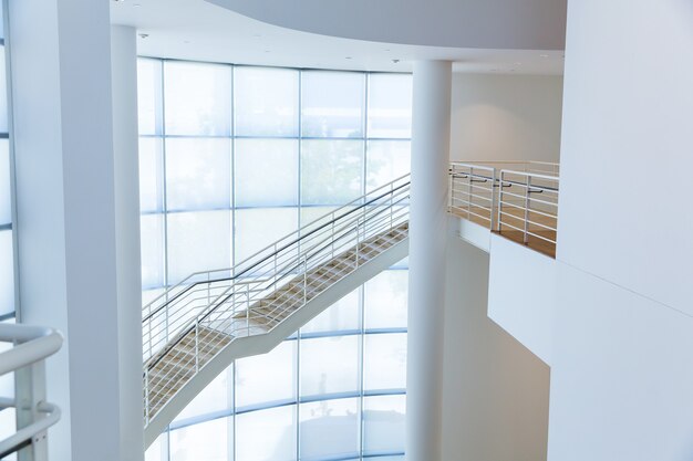 Escalier avec mains courantes en métal contre le mur de verre