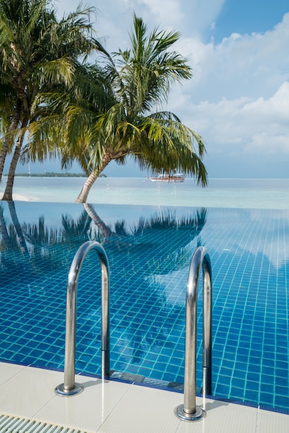 Escalier de piscine avec piscine à débordement et paysage marin comme arrière-plan flou