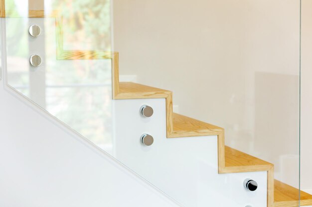 Escalier recouvert de parquet de chêne avec balustrade en verre trempé et épingles chromées