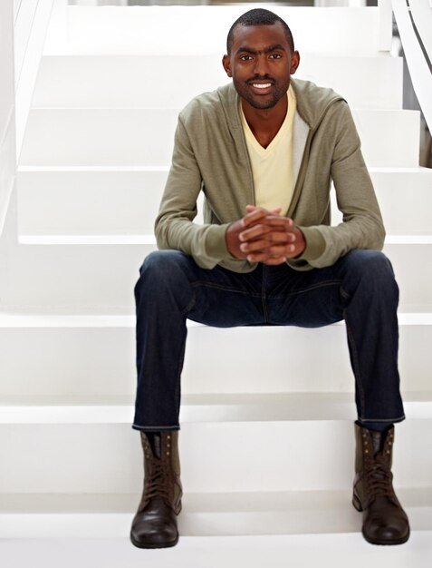 Photo escaliers de bureau et portrait d'un homme noir d'affaires pour la confiance et la fierté de sa carrière professionnelle entreprise de construction et travailleur heureux assis sur les marches avec ambition pour le travail et l'opportunité