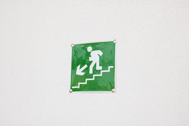 Escaliers de pointeur de signe vert sur le mur