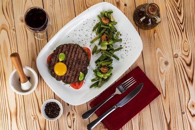 Escalope de boeuf grillée avec jaune et haricots d'asperges. Mise à plat