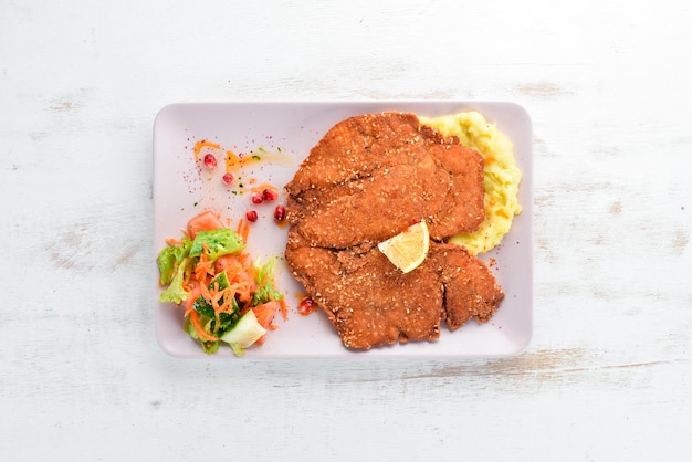 Escalope de poulet avec purée de pommes de terre sur une assiette Sur un fond en bois Vue de dessus Espace libre pour votre texte