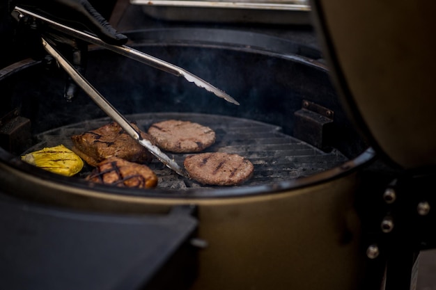 Les escalopes de burger sont grillées. Pique-nique avec des hamburgers. Gril à charbon