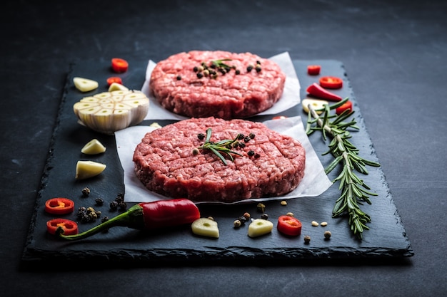 Escalopes de burger de viande crue avec des ingrédients