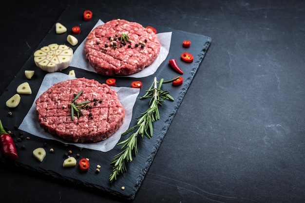 Escalopes de burger de viande crue avec des ingrédients