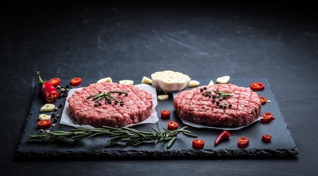 Escalopes de burger de viande crue avec des ingrédients