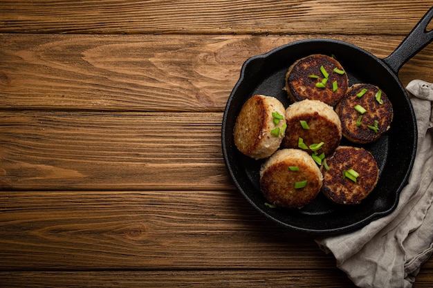 Escalopes faites maison de poulet de poisson ou de viande sur une poêle à frire en fonte noire