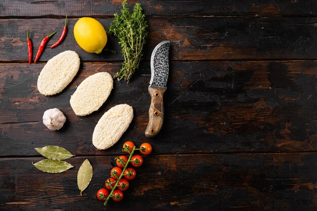 Escalopes de pâté crues panées sur fond de table en bois sombre vue de dessus mise à plat