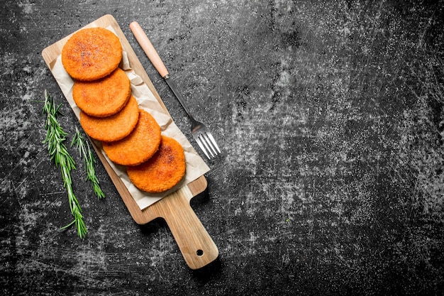 Escalopes de poisson sur papier avec fourchette et romarin