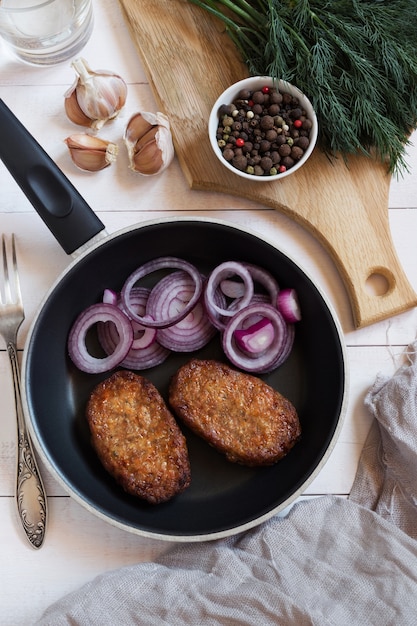 Escalopes de porc aux oignons dans une poêle noire