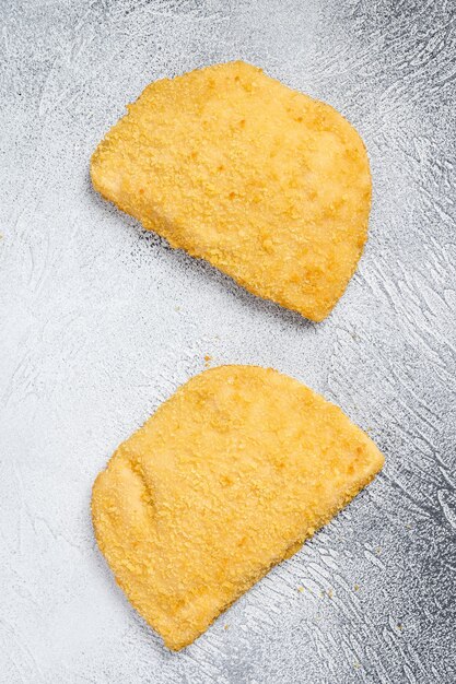 Escalopes de poulet cru cordon bleu sur blanc. Vue de dessus.