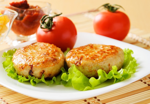 Escalopes de poulet sur la laitue frisée verte.